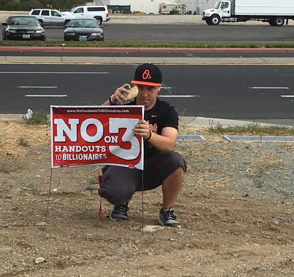 Local 1245 member Michelle Benuzzis son used a rock to put up a No on Question 3 lawn sign