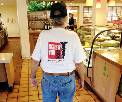 Fred Kramer from the Santa Rosa Chapter of the Local 1245 Retirees Club shows his colors and his true feelings toward Proposition 32, the ballot measure that seeks to gag workers while letting corporations spend unlimited cash to influence elections.   Photo by JV Macor 