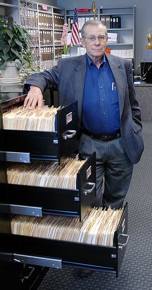 Roger Stalcup in 2008, with the files of grievance resolutions that reflect his quarter-century of work as Secretary of the Review Committee.