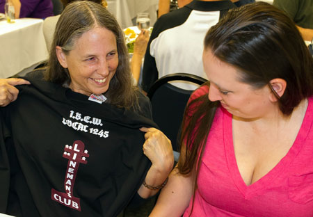 Michele shows off her new Lineman’s Club tee-shirt to daughter Megan at the party celebrating the 10th anniversary of Weakley Hall and the dedication of the Lineman’s Club sign. Photo by John Storey