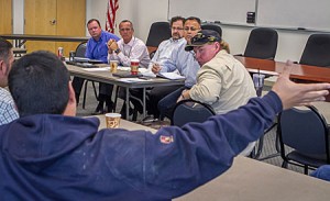 George Unsworth, foreground, discusses training. Turning around to listen is Jack South. At the table in front, from left, are John Higgins, Kevin Knapp, Nick Stavropoulos and Jesus Soto.