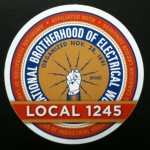 The logo of the International Brotherhood of Electrical Workers. Written across on the bottom is "Local 1245".