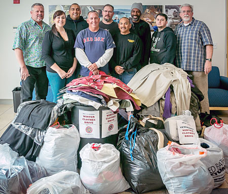 With the 500 pounds of winter clothes they collected for veterans in need are Mike Grandmain, Kendra Barter (Veterans Resource Center of America), Joe Sanchez, John Daniels, Casey Salkauskas, Jaime Tinoco, Walter Carmier, Erick Varela, and Phil Alleman.