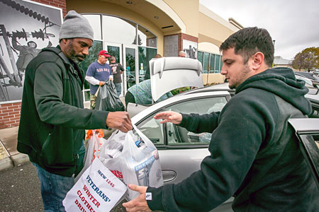 Walter Carmier, left, and Erick Varela load the clothes for delivery.