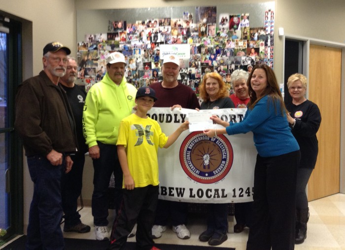10-year-old cancer survivor Cooper Anderson (front left) hands a check to Lisa Schafer of the Northern Nevada Childrens Cancer Foundation. Joining them from left are IBEW 1245 retirees Ron Borst, Cooper's grandfather Rod Thomas, Bob Viera, Jim Lapin, Rita Weisshar, Kathy Preston and Vicki Borst In front, cooper Anderson, and lisa Schafer