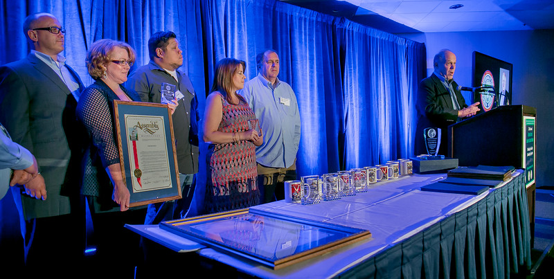 IBEW 1245 Business Manager Tom Dalzell (at podium) credits the Organizing Stewards for “fighting the fight Tom Joad talked about.” Awardees from left: Eric Sunderland, Kristen Rasmussen, Ivan Pereda, Rachel Ramirez Hill and Steven Marcotte