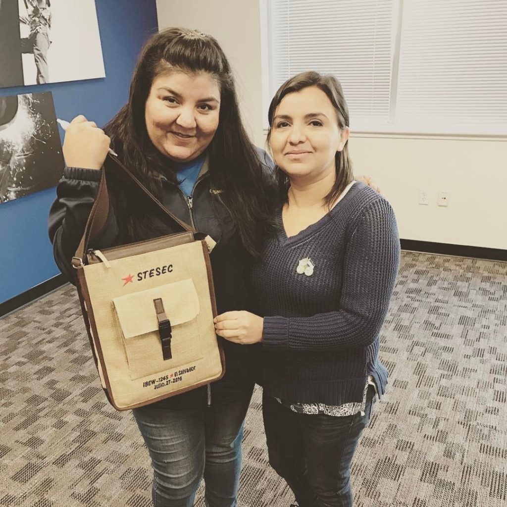 Organizing Steward Nilda Garcia (left) gave Carla Silva her pin of Rosie the Riveter which states “A Woman’s Place is In Her Union!” In exchange, Carla gifted Nilda her satchel with the STESEC insignia embroidered on the flap.