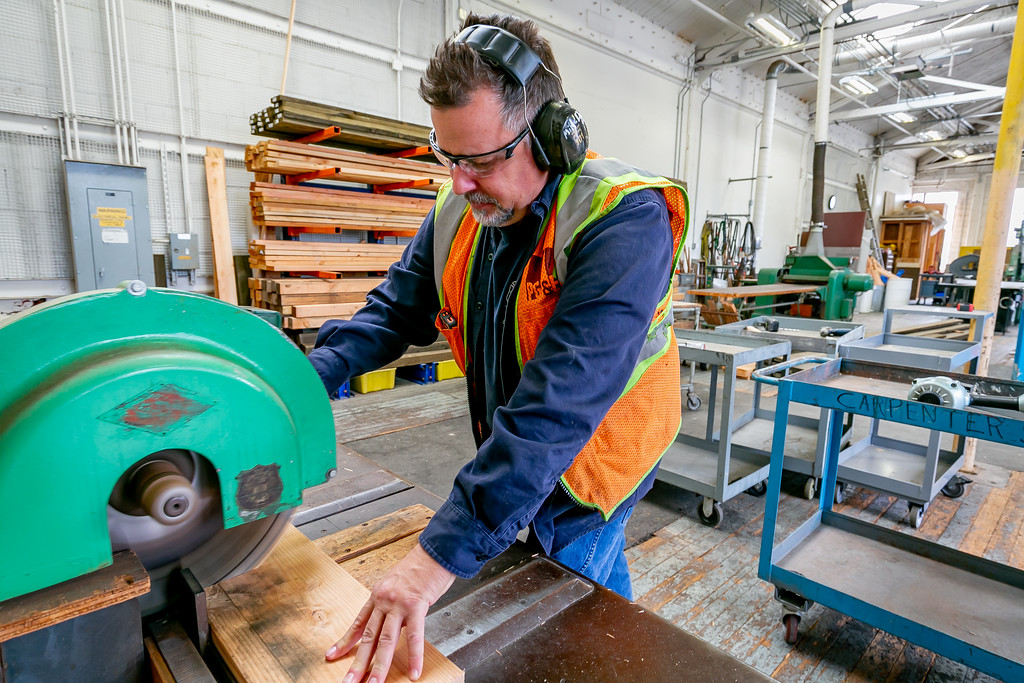 Carpenter Michael Deschaine cuts wood 