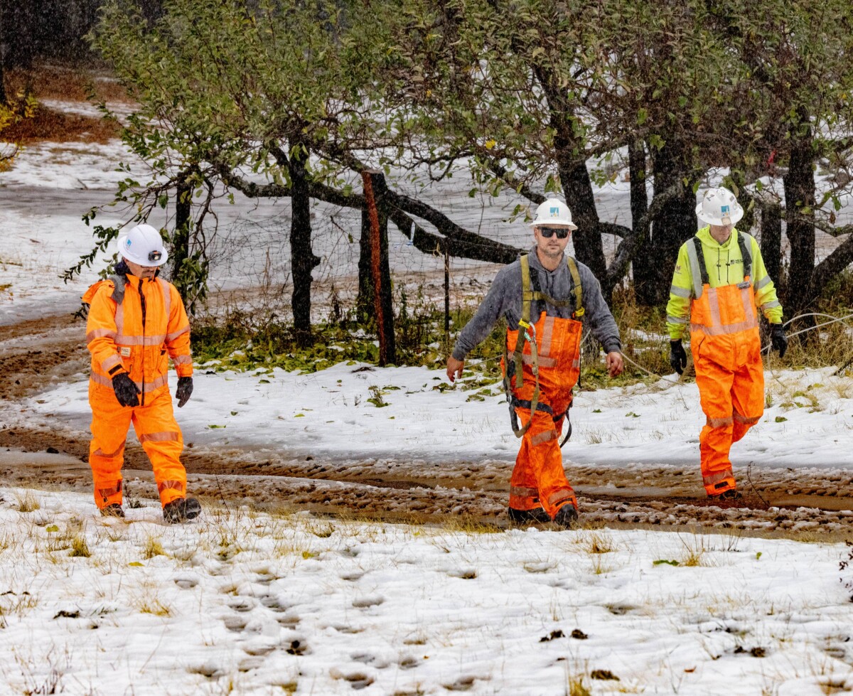 PG&E crews fix a down wire and replace a cross arm after a show storm in Round Mountain, Calif. on November 22, 2024.