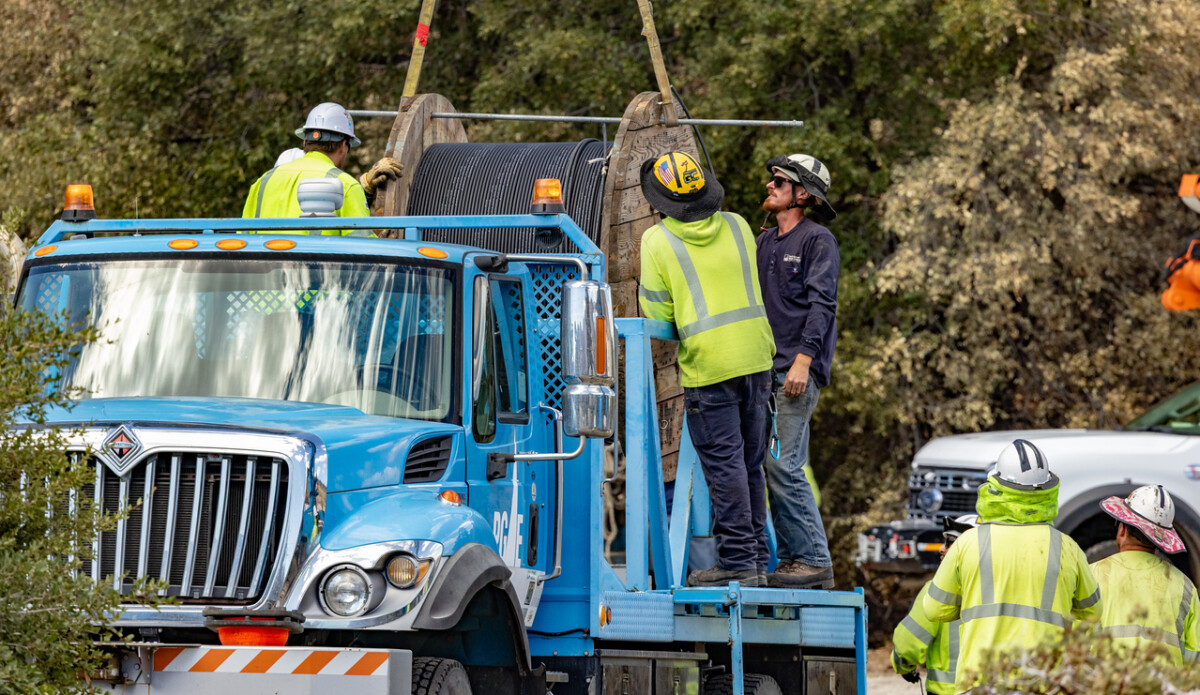 At the staging area, IBEW 1245 crews ready their equipment — preparing reels of line and gear for the long days of restoration work ahead.