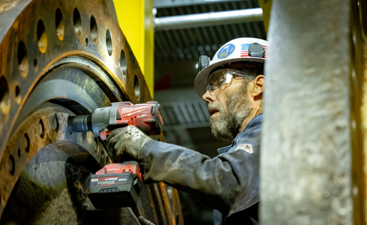 Pat Reilly, plant mechanic torquing fasteners on a massive turbine component inside the Colgate powerhouse.